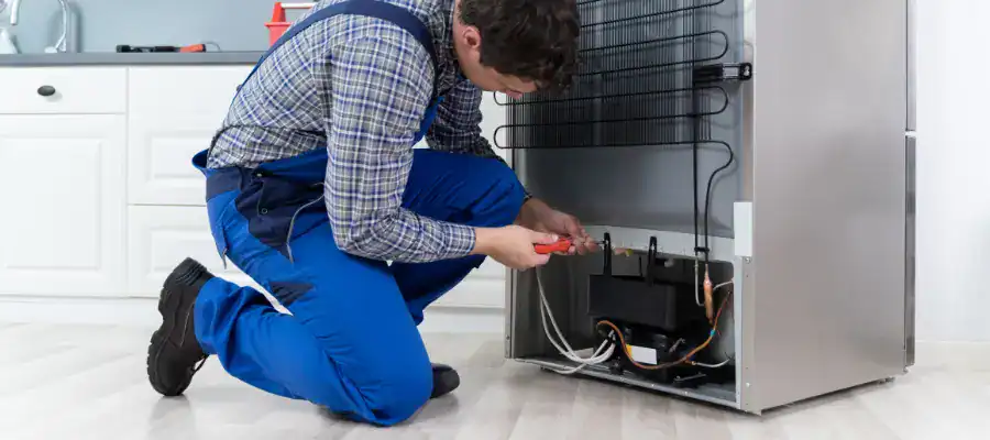 A technician repairs a refirgerator